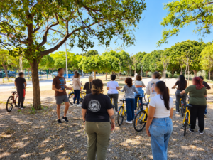 Una foto de la biciescuela en la UMA donde se ve a participantes con sus bicis siguiendo las instrucciones del monitor.